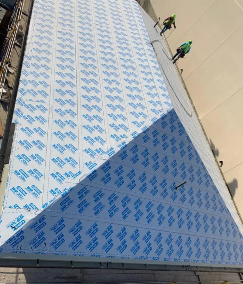 Professional roofers installing underlayment on a metal roof in Pequannock